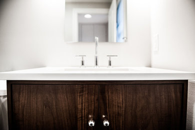 Example of a mid-sized arts and crafts medium tone wood floor and brown floor bathroom design in Philadelphia with furniture-like cabinets, dark wood cabinets and white countertops