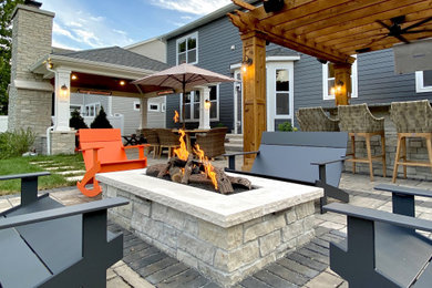 Patio - mid-sized modern backyard concrete paver patio idea in Chicago with a fire pit and a gazebo