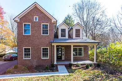 Inspiration for a large timeless red two-story brick exterior home remodel in Other
