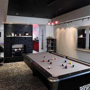 This is an example of a medium sized contemporary fully buried basement in Louisville with grey walls, carpet, a two-sided fireplace and a brick fireplace surround.