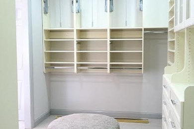 Example of a mid-sized trendy women's carpeted walk-in closet design in Dallas with open cabinets and white cabinets