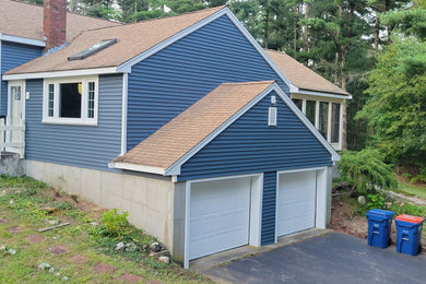 Diseño de fachada de casa azul y marrón tradicional de tamaño medio de una planta con revestimiento de vinilo, tejado de un solo tendido, tejado de teja de madera y tablilla