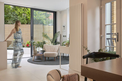 Inspiration for a large contemporary u-shaped kitchen in London with flat-panel cabinets, engineered stone countertops, white splashback, porcelain flooring, a breakfast bar, white floors and white worktops.