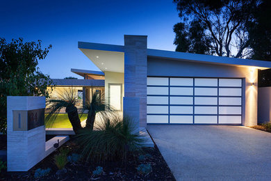 Photo of a large modern one-storey stucco grey house exterior in Perth with a flat roof and a metal roof.