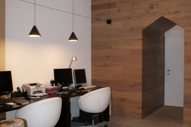 Immagine di uno studio moderno con pareti bianche, scrivania autoportante e pavimento grigio