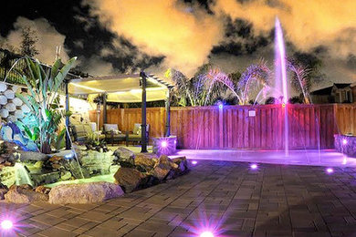Inspiration for a large transitional backyard concrete paver patio fountain remodel in Other with no cover