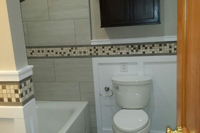 Bathroom - mid-sized contemporary 3/4 gray tile and ceramic tile ceramic tile bathroom idea in New York with an undermount sink, shaker cabinets, black cabinets, quartz countertops, a two-piece toilet and beige walls