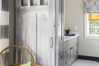 Inspiration for a mid-sized contemporary master ceramic tile, multicolored floor and single-sink bathroom remodel in Boston with beaded inset cabinets, gray cabinets, a one-piece toilet, beige walls, an integrated sink, solid surface countertops, white countertops and a built-in vanity