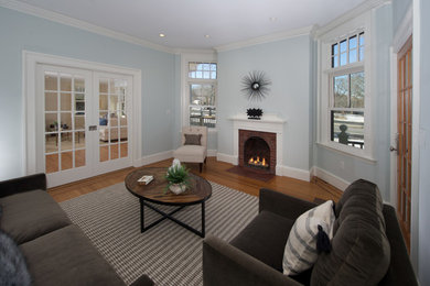 Mid-sized transitional formal enclosed living room in Boston with grey walls, medium hardwood floors, a standard fireplace, a brick fireplace surround, no tv and beige floor.