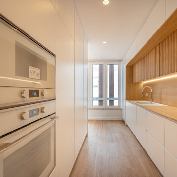 Galley Kitchen with Tall Oven Column and Wood Backsplash
