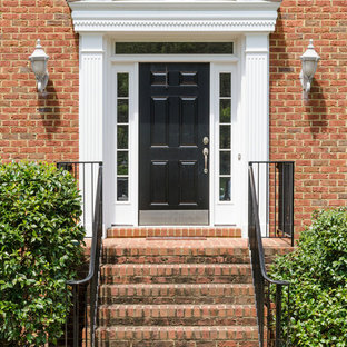 リッチモンドの中サイズの片開きドアトラディショナルスタイルのおしゃれな玄関ドア (黒いドア、赤い壁) の写真