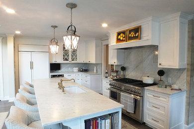 Eat-in kitchen - large transitional l-shaped light wood floor eat-in kitchen idea in Minneapolis with an undermount sink, marble countertops, stone slab backsplash, shaker cabinets, white cabinets, white backsplash, stainless steel appliances and an island