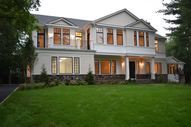 Inspiration for a mid-sized transitional beige two-story wood exterior home remodel in New York with a shingle roof