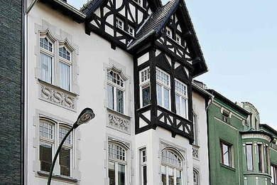 Großes, Vierstöckiges Klassisches Einfamilienhaus mit Putzfassade, weißer Fassadenfarbe, Satteldach, Ziegeldach, schwarzem Dach, Verschalung und Dachgaube in Düsseldorf