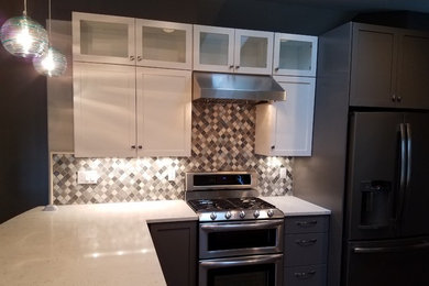 Eat-in kitchen - mid-sized transitional l-shaped dark wood floor eat-in kitchen idea in Seattle with a farmhouse sink, shaker cabinets, white cabinets, quartz countertops, multicolored backsplash, porcelain backsplash and stainless steel appliances