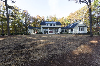 Example of a large arts and crafts beige two-story concrete fiberboard exterior home design in Other with a metal roof