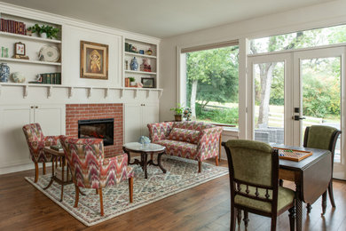 Elegant dark wood floor and brown floor living room photo in Austin with white walls, a standard fireplace and a brick fireplace