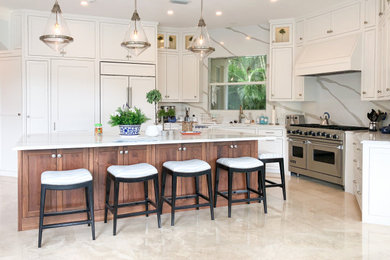 タンパにある高級な広いトランジショナルスタイルのおしゃれなキッチン (シェーカースタイル扉のキャビネット、白いキャビネット、シルバーの調理設備、ベージュの床、白いキッチンカウンター) の写真