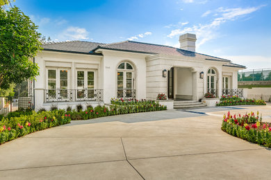 Example of a large transitional white two-story stucco house exterior design in Los Angeles with a hip roof and a tile roof