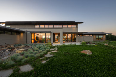 Mid-sized modern beige two-story concrete fiberboard and clapboard exterior home idea in Portland with a metal roof and a brown roof