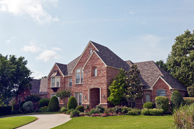 Elegant red two-story brick house exterior photo in Philadelphia with a shingle roof