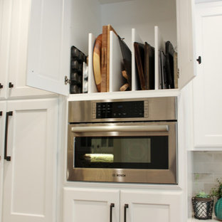 This is an example of a large traditional u-shaped eat-in kitchen in Other with a single-bowl sink, recessed-panel cabinets, white cabinets, quartz benchtops, beige splashback, porcelain splashback, stainless steel appliances, medium hardwood floors and with island.