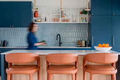Inspiration for a mid-sized modern vinyl floor and vaulted ceiling eat-in kitchen remodel in Houston with an undermount sink, flat-panel cabinets, blue cabinets, quartz countertops, blue backsplash, ceramic backsplash, paneled appliances, an island and white countertops