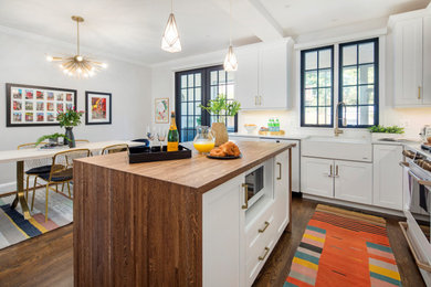 Trendy l-shaped medium tone wood floor and brown floor open concept kitchen photo in DC Metro with shaker cabinets, white cabinets, marble countertops, white backsplash, ceramic backsplash, white appliances, an island, white countertops and a farmhouse sink