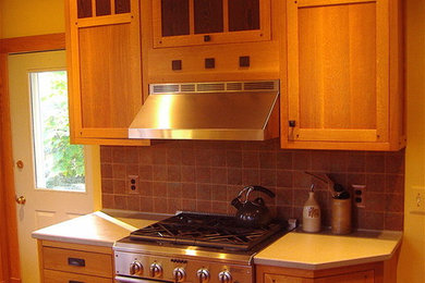 Elegant u-shaped medium tone wood floor enclosed kitchen photo in Other with shaker cabinets, medium tone wood cabinets, gray backsplash, stainless steel appliances and an island
