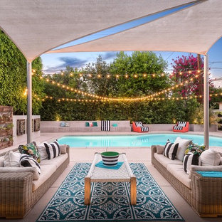 Moderner Patio hinter dem Haus mit Kübelpflanzen, Betonplatten und Markisen in Los Angeles