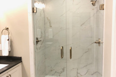 Inspiration for a transitional ceramic tile alcove shower remodel in Birmingham with beaded inset cabinets, quartz countertops and black countertops