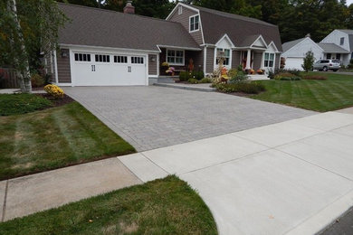 This is an example of a front yard driveway in Other with brick pavers.
