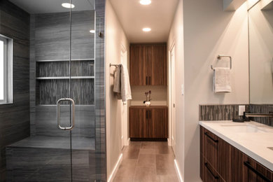 Inspiration for a mid-sized contemporary master porcelain tile alcove shower remodel in San Francisco with flat-panel cabinets, dark wood cabinets, white walls, an undermount sink and solid surface countertops