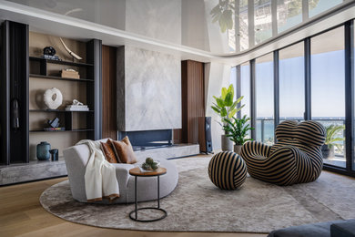 Large minimalist open concept light wood floor, beige floor and wall paneling family room photo in Miami with a music area, gray walls, a standard fireplace, a stone fireplace and a wall-mounted tv