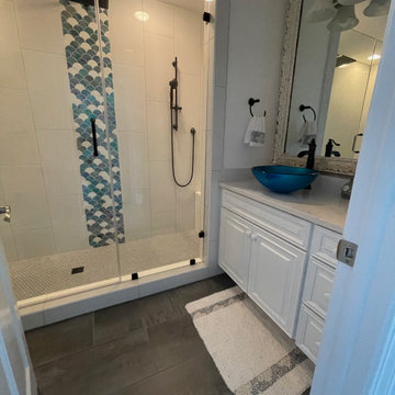 Beautiful bathroom with vertical 12x24 white tiles and a scallop waterfall.
