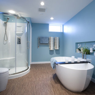 Inspiration pour une salle de bain design pour enfant avec une baignoire indépendante, un sol en bambou, un placard à porte plane, des portes de placard noires, une douche d'angle, un mur bleu, un sol marron et une cabine de douche à porte coulissante.