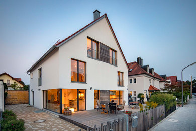 Moderne Doppelhaushälfte mit Putzfassade, weißer Fassadenfarbe, Satteldach, Ziegeldach und rotem Dach in München