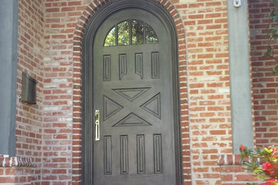 Single front door - traditional brick floor single front door idea in Dallas with red walls and a gray front door