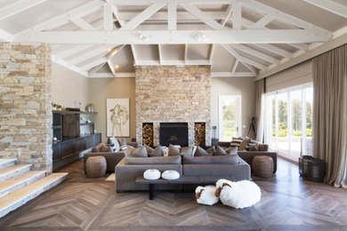 Photo of a large country open plan living room in Melbourne with a stacked stone fireplace surround.