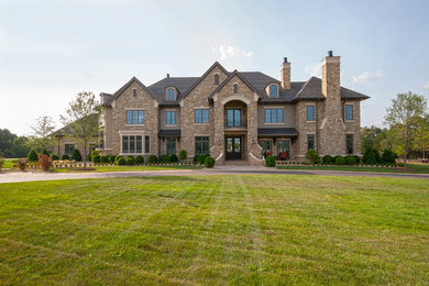 Inspiration for a huge timeless beige three-story stone exterior home remodel in Other
