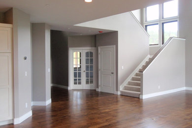 Inspiration for a mid-sized timeless open concept dark wood floor living room remodel in Denver with brown walls and no fireplace