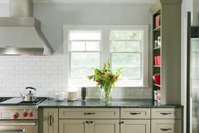 Example of a mid-sized l-shaped medium tone wood floor kitchen design in Hawaii with shaker cabinets, green cabinets, granite countertops, white backsplash, subway tile backsplash, stainless steel appliances and an island