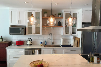 Kitchen - mid-sized contemporary kitchen idea in Vancouver with an undermount sink, shaker cabinets, white cabinets, quartz countertops, white backsplash, subway tile backsplash, stainless steel appliances and an island