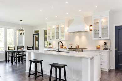 Photo of a contemporary single-wall kitchen in Ottawa with a submerged sink, shaker cabinets, white cabinets, engineered stone countertops, an island and white worktops.