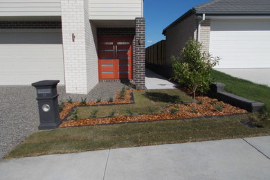Photo of a small contemporary front yard full sun formal garden for spring in Other with a garden path and concrete pavers.
