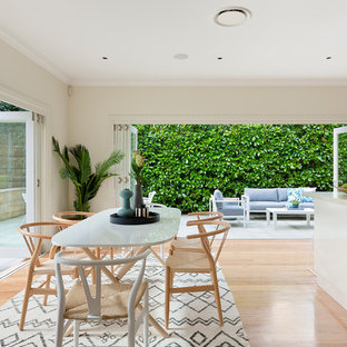 シドニーの広いビーチスタイルのLDKの画像 (ベージュの壁、無垢フローリング、茶色い床)