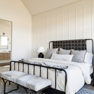 Mittelgroßes Landhausstil Hauptschlafzimmer mit weißer Wandfarbe, braunem Holzboden, Kamin, verputzter Kaminumrandung, gewölbter Decke und Wandpaneelen in Boise