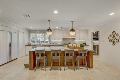 Open concept kitchen - large eclectic l-shaped travertine floor and beige floor open concept kitchen idea in Dallas with a farmhouse sink, shaker cabinets, white cabinets, soapstone countertops, gray backsplash, ceramic backsplash, stainless steel appliances, an island and black countertops