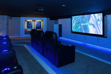Inspiration for a contemporary home theatre in Other with white walls, carpet, a projector screen and blue floor.