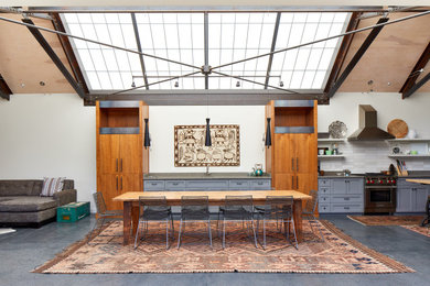Inspiration for a farmhouse open concept concrete floor, gray floor and exposed beam family room remodel in San Francisco